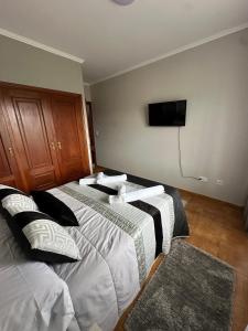 a bedroom with two beds and a flat screen tv at CASA Nieves in O Grove