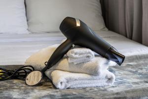 a hair dryer sitting on top of a pile of towels at Yume On Paulista in São Paulo
