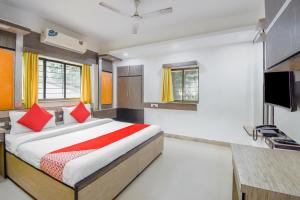 a bedroom with a bed and a flat screen tv at Super hotel O Adri 2 in Kolkata