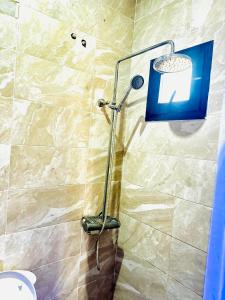 una ducha con cabezal de ducha en un baño en Teranga SN, en Dakar 3 fotos más