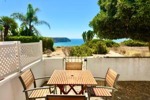 a wooden table and chairs with a view of the ocean at Casa Mareta in Sagres