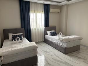 a bedroom with two beds and a window at Zayed hotel in Sheikh Zayed