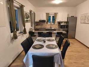 a dining room with a table and chairs and a kitchen at Villa Leen Dubrovnik in Ðurinići