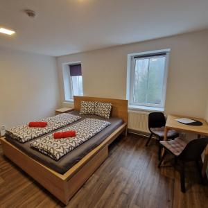 a bedroom with a bed with red pillows on it at Apartmány RADOST in Kovářská