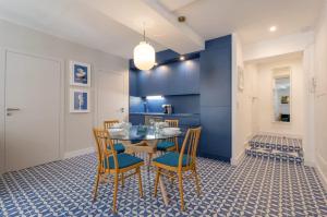 里昂Strada - Furnished apartment - Downtown Lyon的一间有蓝色墙壁和桌子和椅子的餐厅