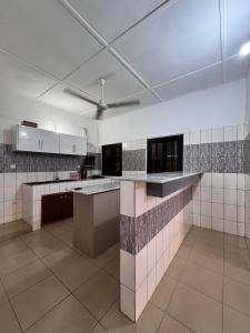 a large kitchen with white walls and a ceiling at Résidence Agbevivi in Aného
