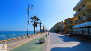 a street next to a beach with palm trees and buildings at La Finestra Sul Mare in Torretta +13 photos