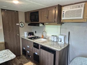 a small kitchen with a sink and a microwave at Moceanset Getaways - Elegant, Ocean, Mountain and Sunset Views "Camping Experience" in Dingwall