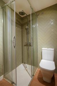 a bathroom with a toilet and a glass shower at GALIHOST - Casa Ría de Vigo in Redondela +33 photos