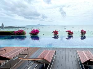 a swimming pool with potted flowers on the water at Centric Sunset Beach in Pattaya Central