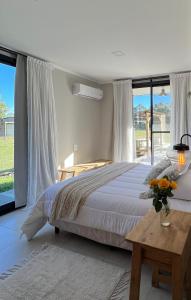 a bedroom with a bed and a table with flowers on it at Posadas Las Chacritas in Chajarí