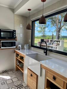 a kitchen with a sink and a large window at Posadas Las Chacritas in Chajarí