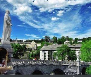 a statue of a man standing on a bridge at Notre Dame AUXILIATRICE in Lourdes