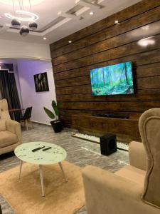 a living room with a tv on a wooden wall at Richj luxury apartment in Benin City
