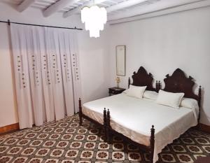 a bedroom with a large bed and a curtain at Benafique La casa del Ciprés Cortegana in Cortegana +11 photos