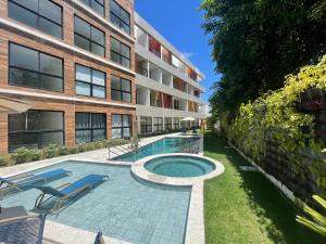 una piscina frente a un edificio en Maré Alta Beach Hall by AFT, en Tamandaré