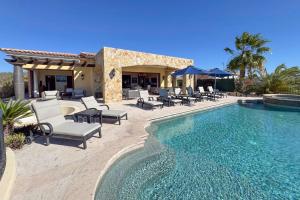a villa with a swimming pool and patio furniture at Ocean & Desert Hacienda Charm Villa in San José del Cabo