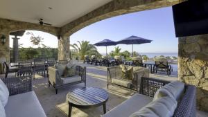 a patio with chairs and tables and the ocean at Ocean & Desert Hacienda Charm Villa in San José del Cabo