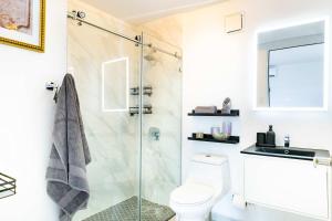 a bathroom with a toilet and a glass shower at 6 Bed 4 Bath Family Houses A8 w 2 Private Pools Dorado del Mar in Dorado