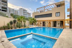 a swimming pool in front of a building at New 3 BD Condo with Pool and Gym in Cabo San Lucas