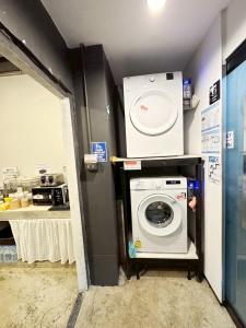 een wasruimte met een wasmachine en een wasmachine bij EK Silomhostel in Bangkok
