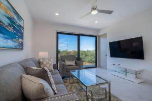 a living room with a couch and a flat screen tv at Find peace in this 2 BD condo in Cabo San Lucas