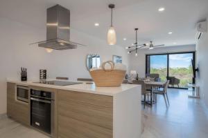a kitchen with a counter top and a dining room at Find peace in this 2 BD condo in Cabo San Lucas