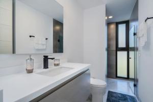 a white bathroom with a sink and a toilet at Find peace in this 2 BD condo in Cabo San Lucas +18 photos