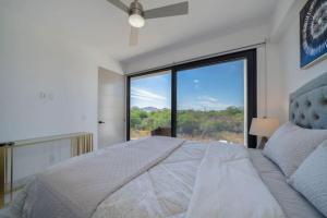 a bedroom with a large bed and a large window at Find peace in this 2 BD condo in Cabo San Lucas