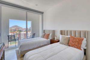 una camera da letto con due letti e un balcone di 3 BD Penthouse Jacuzzi BBQ Near Medano Beach a Cabo San Lucas Altre 56 foto