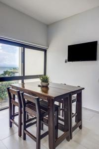 a dining room with a wooden table and chairs at 2BD Condo with Roof shared Pool in Cruz de Huanacaxtle