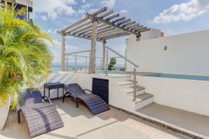 a patio with a table and chairs and a pool at 2BD Condo with Roof shared Pool in Cruz de Huanacaxtle