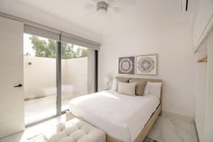 a bedroom with a large bed and a large window at AMATERRA modernos aptos cerca a la playa in Cabo San Lucas +17 photos