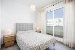 コニル・デ・ラ・フロンテーラにあるConil Seaside Hideawayのベッドと大きな窓のある寝室 +24枚の写真