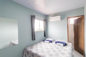 a bedroom with a bed with two pillows on it at Pousada Gonçalves in Tangará