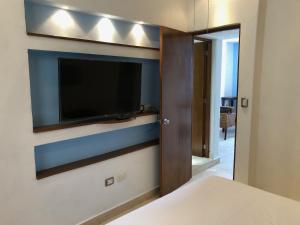 a bedroom with a flat screen tv on a wall at Cozumel Frente al Mar in Cozumel