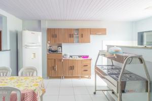 a kitchen with a stove and a refrigerator at Pousada Gonçalves in Tangará
