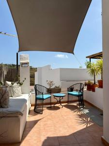 a patio with a couch and chairs and a table at Casa Maroma in Cómpeta +30 photos