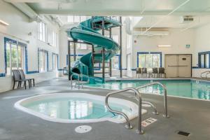 a swimming pool with a slide in a building at Canalta Cochrane in Cochrane