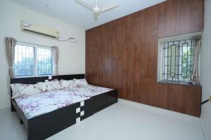 Un dormitorio con una cama con una pared de madera. en Newly Built Beautiful and Luxurious 3BHK in Tirupati with Fully Functional Kitchen,for upto 25 guests, en Tirupati