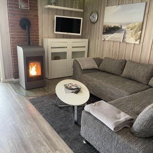 a living room with a couch and a fireplace at Dreibogen Ferienwohnung Lolle in Glücksburg