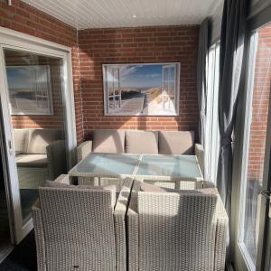 a patio with a hot tub and wicker chairs at Dreibogen Ferienwohnung Lolle in Glücksburg