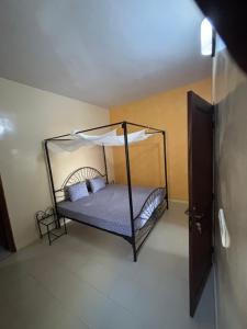 a bedroom with a bed with a canopy at Maison tranquille in Saly Portudal +15 photos