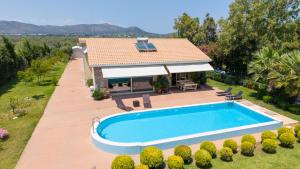 a villa with a swimming pool and a house at Schinias Paradise in Marathon