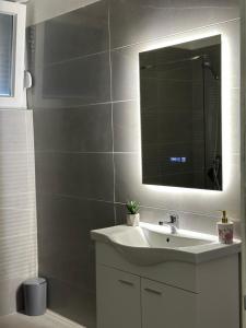 a bathroom with a sink and a mirror at Apartman Kraljević in Ljubuški +16 photos