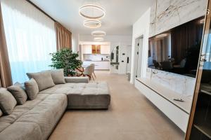 a living room with a couch and a kitchen at Odyssey Sea-View Apartament in Mamaia Nord