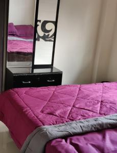 コダイカナルにあるBethel homestayの紫色の掛け布団と鏡付きのベッド
