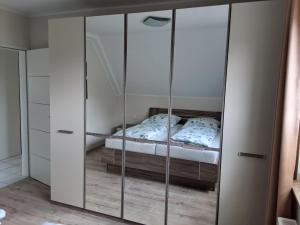 a bedroom with a mirrored closet with a bed in it at FeWo21 Ferienwohnung im schönen Münsterland in Lüdinghausen
