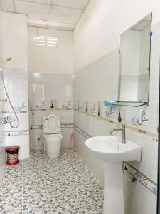 une salle de bains blanche avec toilettes et lavabo dans l'établissement Hotel Mimosa 2, à Phan Rang