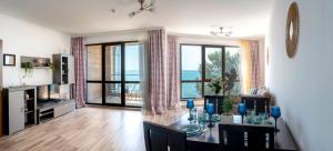 a living room with a table and a large window at CABA Apartment in Varna City